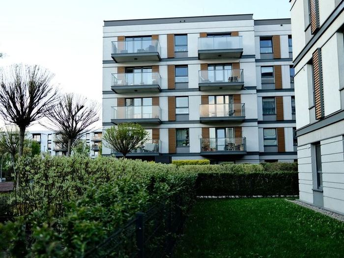 Symbolbild: modernes Mehrfamilienhaus mit Balkonen und Garten